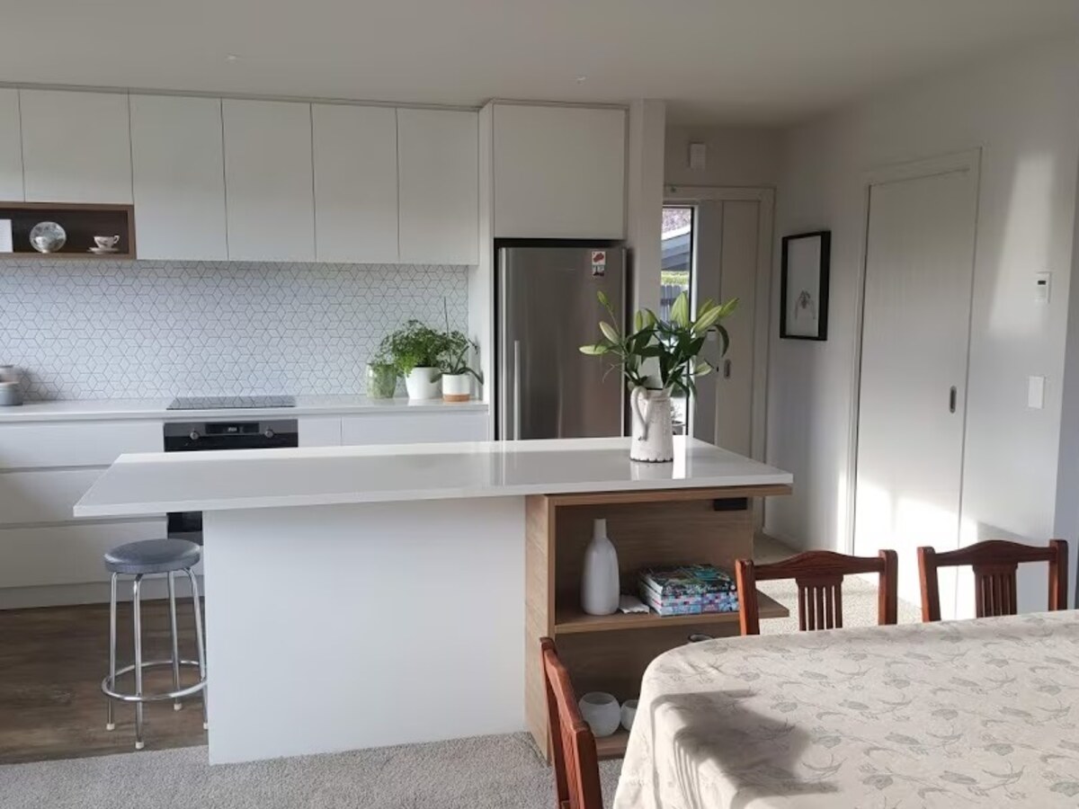 Kitchen island before: a wide, level shot showing the full kitchen and dining area